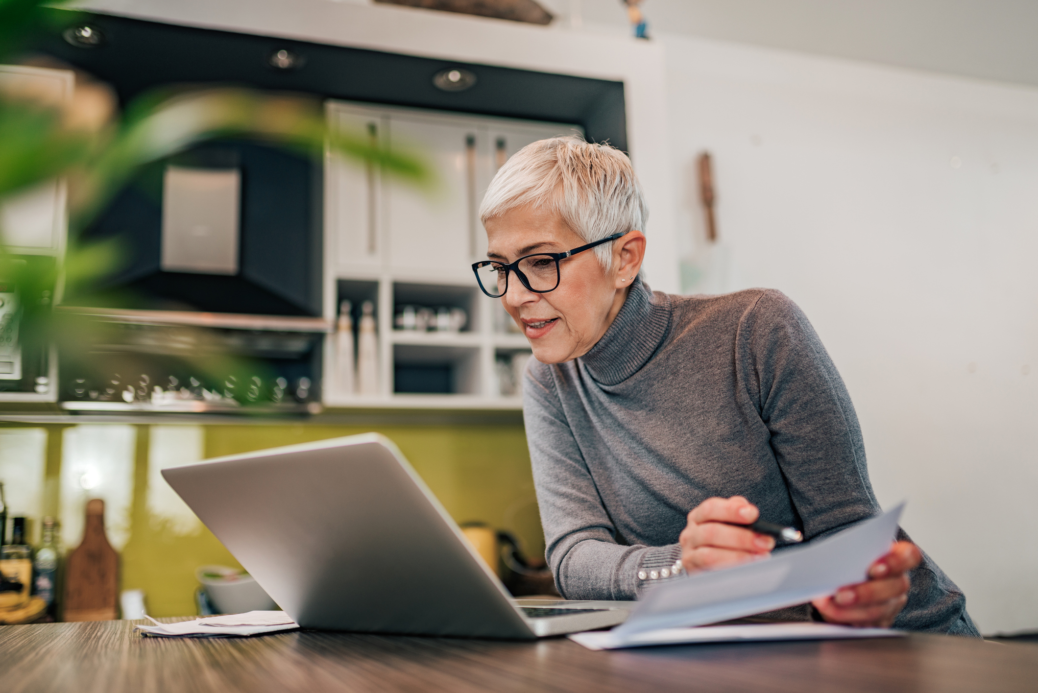 Charming woman holding papers and looking at laptop, portrait. - Castle ...